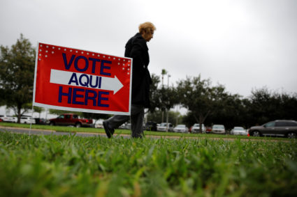A woman arrives at a polling station at the Lark Community Center as the early voting for midterm elections starts in Texas. Photo by Carlos Barria/REUTERS