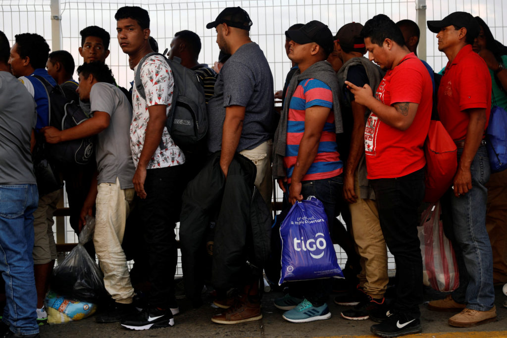 Central American migrants wait on the bridge that connects Mexico and Guatemala to cross into Mexico to continue their tri...