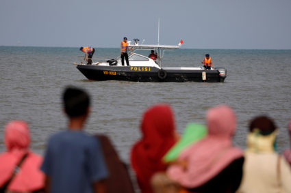 People watch rescue team members on a boat before they head to the Lion Air, flight JT610, sea crash location in the north coast of Karawang regency, West Java province, Indonesia. Photo by Beawiharta/Reuters