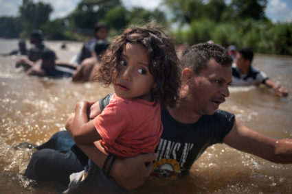Luis Acosta holds 5-year-old Angel Jesus, both from Honduras, as a caravan of migrants from Central America en route to the United States crossed through the Suchiate River into Mexico from Guatemala in Ciudad Hidalgo, Mexico on Oct. 29, 2018. Photo by REUTERS/Adrees Latif