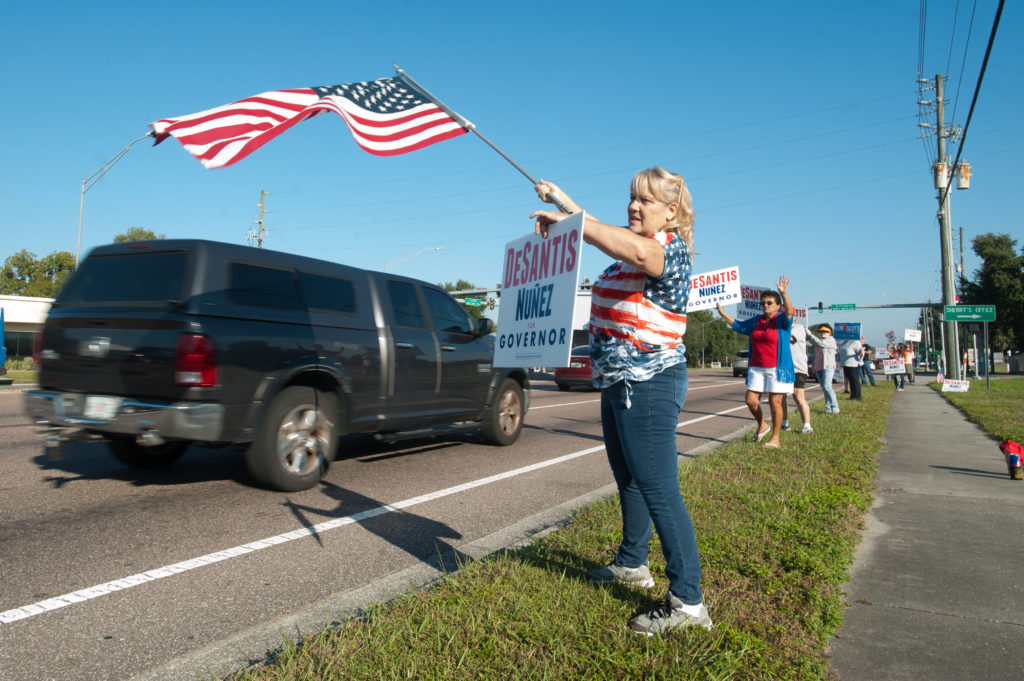 Kathleen Callahan wore a flag to wave a flag and a sign of her favorite candidate in New Port Richey, Florida. Photo by Ja...