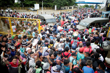 Honduran migrants, part of a caravan trying to reach the U.S., storm a border checkpoint to cross into Mexico, in Tecun Uman, Guatemala October 19, 2018. Photo by REUTERS/Ueslei Marcelino