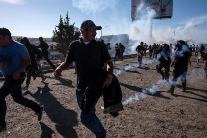 Central American migrants run along the Tijuana River near the border crossing in Tijuana, Mexico, after the U.S. Border Patrol threw tear gas to disperse the crowd attempting to cross into the U.S. Photo by Guillermo Arias/AFP/Getty Images