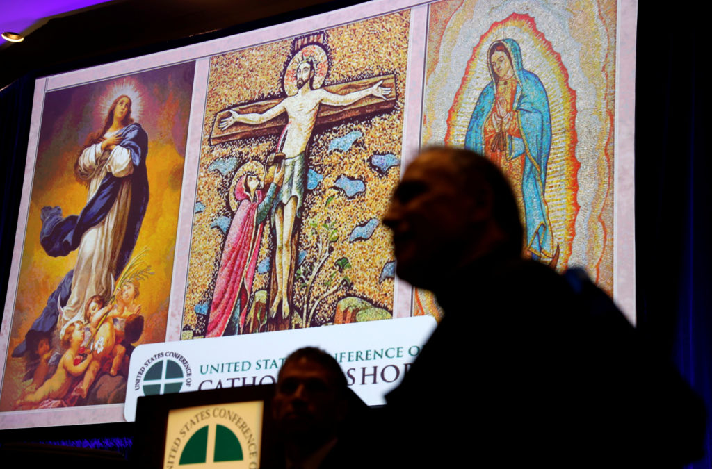 Cardinal Daniel DiNardo (R), president of the U.S. Conference of Catholic Bishops, speaks with other attendees at the USCC...