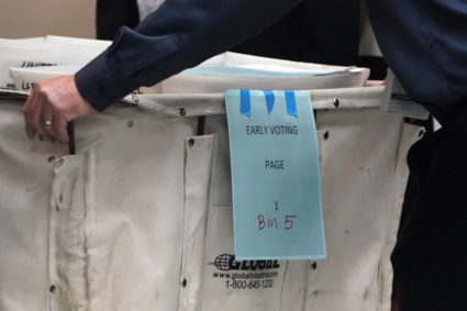 A worker pushes a cart full of early ballots before a ballot recount in Lauderhill, Florida. Photo by Carlo Allegri/Reuters