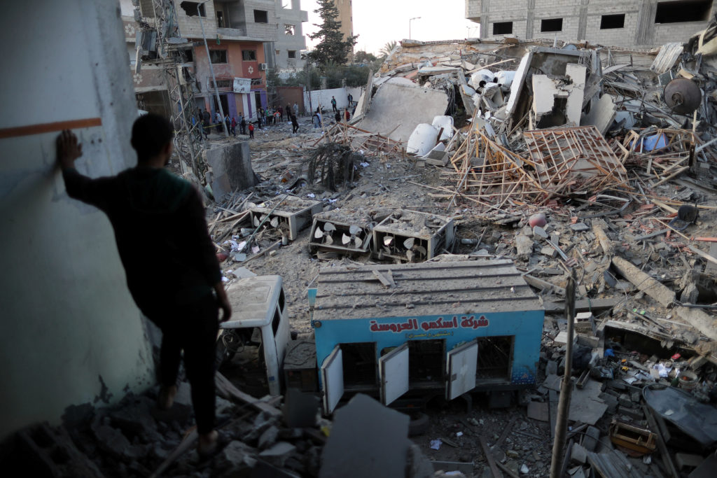 A Palestinian man looks at the remains of Hamas's TV station building that was destroyed by Israeli air strikes, in Gaza C...