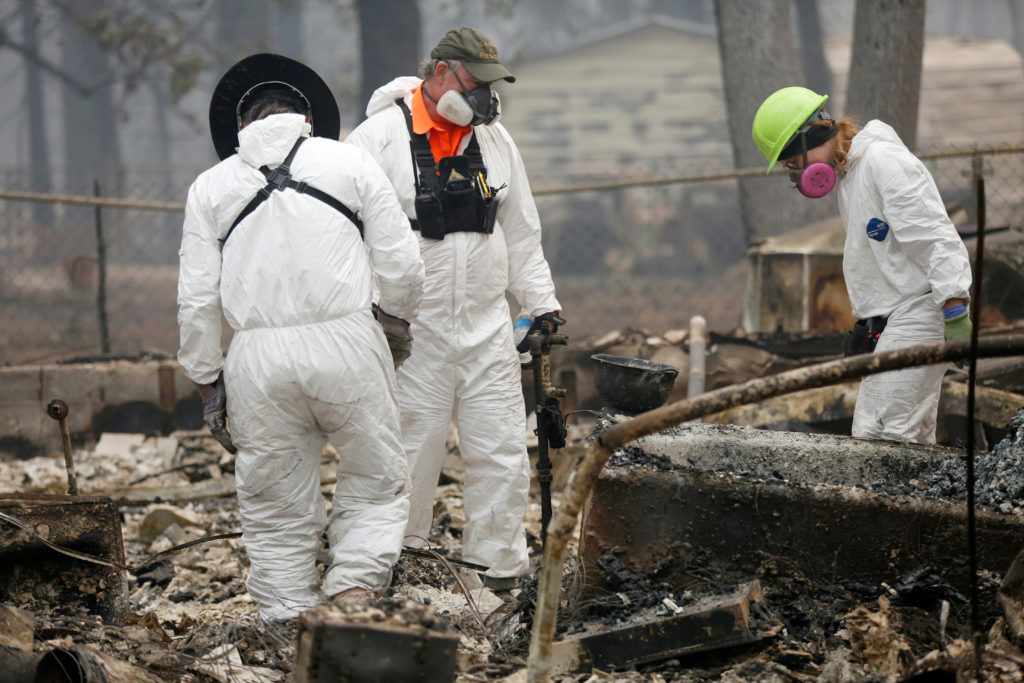 An anthropologist (right) examines the site of a home destroyed by the Camp Fire in Paradise, California, on Nov. 14. Phot...