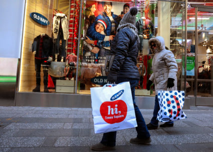 People are seen with shopping bags in Times Square while Black Friday shopping in New York City. High consumer confidence often translates to increased spending. Photo by Brendan McDermid/Reuters