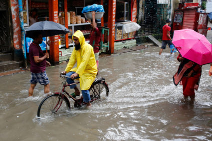 Man rides a bicycle on the water as roads are flooded due to heavy rain in Dhaka, Bangladesh July 25, 2017. Photo by REUTERS/Mohammad Ponir Hossain