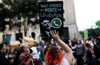 A woman holds a sign with an image of presidential candidate Jair Bolsonaro that reads "He lies in WhatsApp," during a protest against Bolsonaro in Sao Paulo, Brazil, October 20, 2018. Photo by REUTERS/Nacho Doce