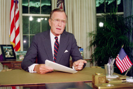 President George H.W. Bush poses for photographers after his address to the nation, September 1991, in the Oval Office of the White House. Photo by Luke Frazza/AFP/Getty Images