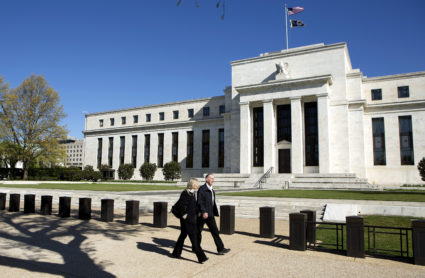 Pedestrians walk past the Federal Reserve Building in Washington, D.C. Photo by Joshua Roberts/Reuters