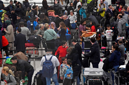 Passengers wait in the queue for check-in in the South Terminal building at Gatwick Airport, after the airport reopened to flights following its forced closure because of drone activity, in Gatwick, Britain, December 21, 2018.Photo by Toby Melville/Reuters