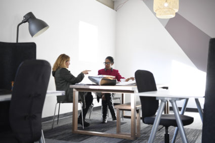 Two women sit at a workspace at Women in Kind. Women in Kind is a co-working space rented out by various small businesses and individuals. Though the space is occupied mostly by women, some men do utilize it. Photo by AAron Ontiveroz/The Denver Post via Getty Images