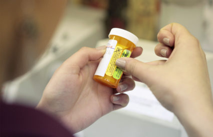 A pharmacy employee places instructional stickers on a bottle as she works to fill a prescription while working at a pharmacy in New York. Photo by Lucas Jackson /Reuters