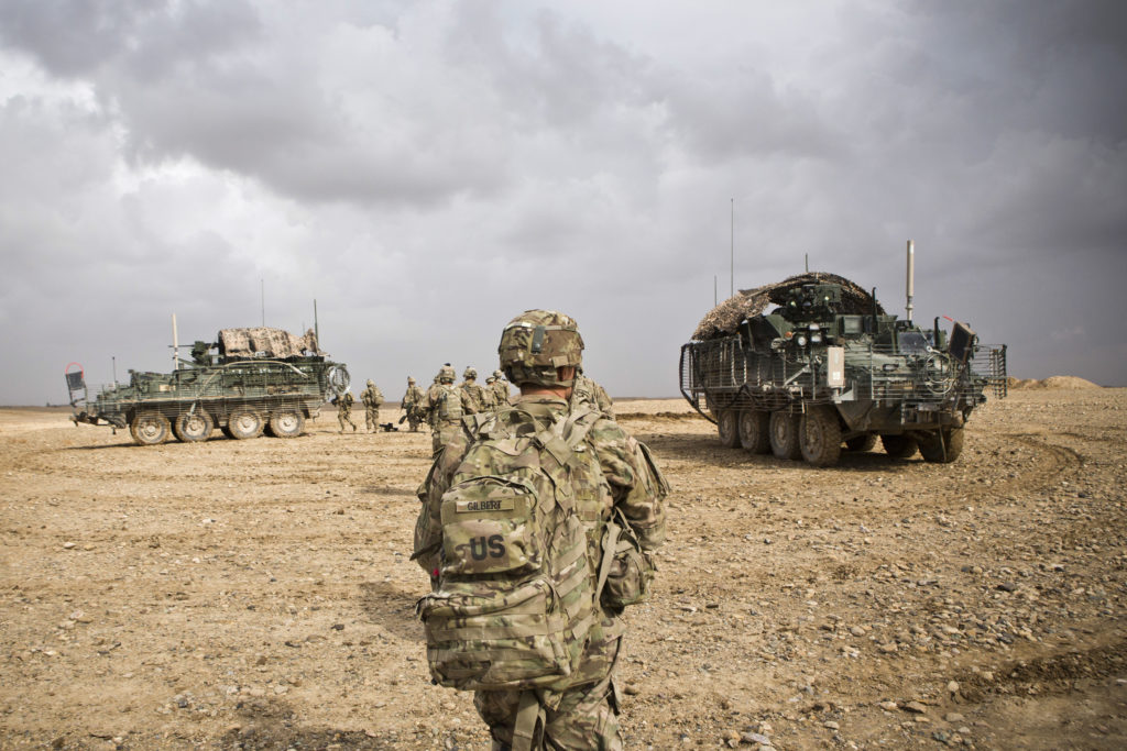 U.S. Army soldiers with Charlie Company, 36th Infantry Regiment, 1st Armored Division head back to their vehicles at the e...