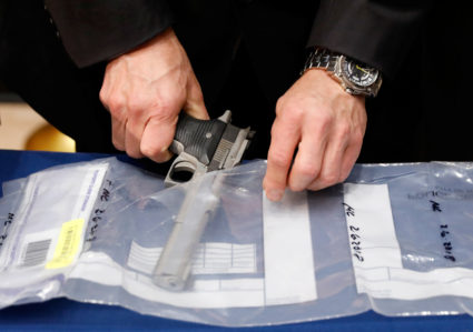 A confiscated handgun is placed into an evidence bag during a news conference about a gun bust at New York City Police Headquarters in New York. Photo by Brendan McDermid/Reuters
