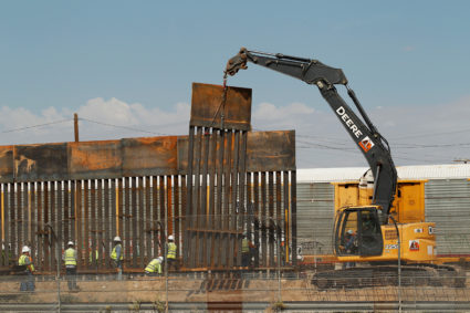 U.S. workers are seen next to heavy machinery while working on a new bollard wall in El Paso, Texas, as seen from the Mexican side of the border in Ciudad Juarez. Photo by Jose Luis Gonzalez/Reuters