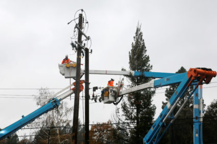 PG&E crew work on power lines to repair damage caused by the Camp Fire in Paradise, California, on November 21, 2018. Photo by Elijah Nouvelage/Reuters