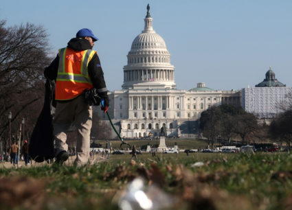 A worker picks up trash on the National Mall near the U.S. Capitol building as the partial government shutdown continues in Washington, D.C. Photo by Jim Young/Reuters
