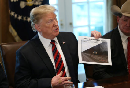 President Donald Trump holds up a photo of a "Typical Standard Wall Design" as he hosts a "roundtable discussion on border security and safe communities" with state, local, and community leaders in the Cabinet Room of the White House in Washington, D.C. Photo by Leah Millis/Reuters