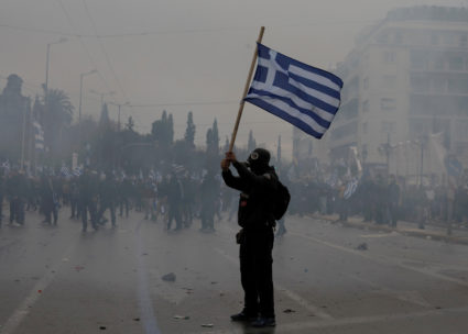 A protester holds a Greek national flag as he takes a part in a demonstration against the agreement reached by Greece and Macedonia to resolve a dispute over the former Yugoslav republic's name, in Athens, Greece on January 20, 2019. Photo by Alkis Konstantinidis/Reuters