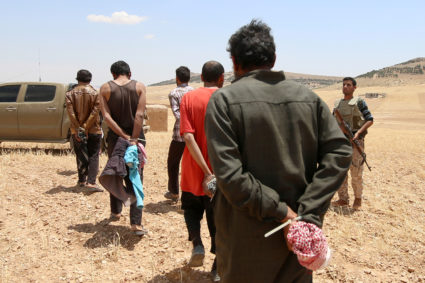 Men, who the Democratic Forces of Syria fighters claimed were Islamic State fighters, walk as they are taken prisoners after SDF advanced in the southern rural area of Manbij, in Aleppo Governorate in Syria on May 31, 2016. Photo by Rodi Said/Reuters