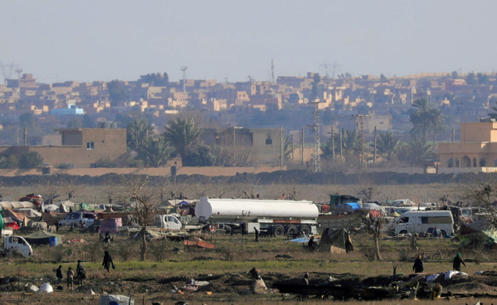 Islamic state members walk in the last besieged neighborhood in the village of Baghouz, Deir Al Zor province, Syria Feb. 1...