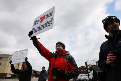 MORGANTOWN, WV - MARCH 02: West Virginia teachers, students and supporters hold signs on a Morgantown street as they continue their strike on March 2, 2018 in Morgantown, West Virginia. Despite a tentative deal reached Tuesday with the state's governor, teachers across West Virginia continued to strike on Friday as the Republican-controlled state legislature debated the governor's deal. (Photo by Spencer Platt/Getty Images)
