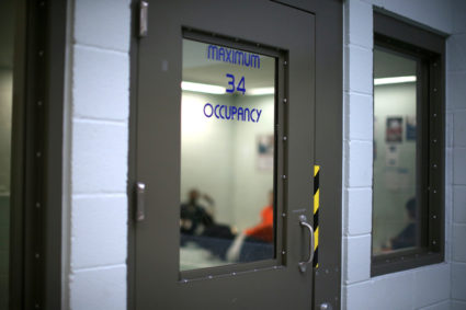 FILE PHOTO: Immigrants sit in a cell for incoming ICE detainees at the Adelanto immigration detention center, which is run by the Geo Group Inc (GEO.N), in Adelanto, California, U.S., April 13, 2017. To match Insight USA-IMMIGRATION/DETENTION REUTERS/Lucy Nicholson/File Photo - RC1517CBE380