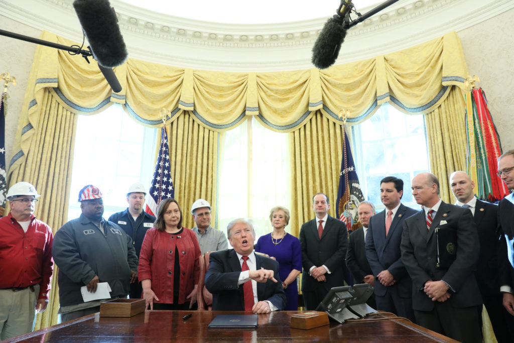 President Donald Trump signs an Executive Order at a meeting with manufacturers and manufacturing workers in the Oval Offi...