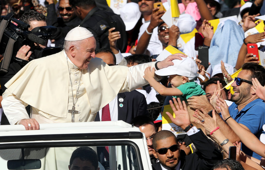 Pope Francis is greeted by a boy as he arrives to hold a mass at Zayed Sports City Stadium in Abu Dhabi, United Arab Emira...
