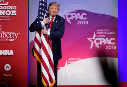 U.S. President Donald Trump hugs the U.S. flag as he arrives to speak at the Conservative Political Action Conference (CPAC) annual meeting at National Harbor in Oxon Hill, Maryland, U.S., March 2, 2019. Photo by Joshua Roberts/Reuters