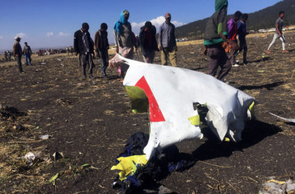 People walk past a part of the wreckage at the scene of the Ethiopian Airlines Flight ET 302 plane crash, near the town of Bishoftu, southeast of Addis Ababa, Ethiopia March 10, 2019. Photo by Tiksa Negeri/Reuters