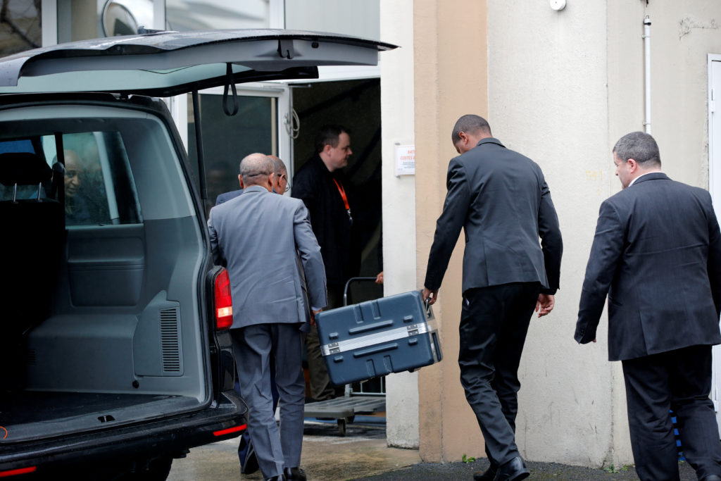 Men unload a case from a diplomatic car from the Ethiopian Embassy outside the headquarters of France's BEA air accident i...