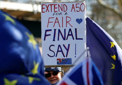 An anti-Brexit protester holds a placard outside the Houses of Parliament in London as members of Parliament voted to delay the deadline for when the UK would leave the EU. Photo by Peter Nicholls/Reuters