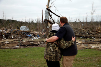 A man hugs Julie Morrison while looking at the remains of her home following a string of tornadoes that resulted in several fatalities in Beauregard, Alabama, U.S., March 4, 2019. Photo by REUTERS/Elijah Nouvelage