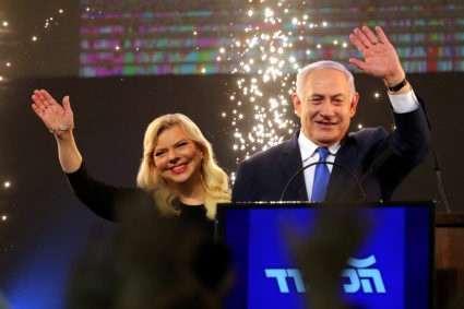 Israeli Prime Minister Benjamin Netanyahu and his wife Sara wave as Netanyahu speaks following the announcement of exit polls in Israel's parliamentary election at the party headquarters in Tel Avi on April 10, 2019. Photo by REUTERS/Ammar Awad