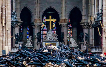 A view of the cross and sculpture of Pieta by Nicolas Coustou in the background of debris inside Notre-Dame de Paris, in the aftermath of a fire that devastated the cathedral, during the visit of French Interior Minister Christophe Castaner (not pictured) in Paris, France. Photo by Christophe Petit Tesson via Reuters