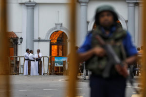 Priests are seen in the background as a security personnel stands guard in front of St Anthony's Shrine, days after a string of suicide bomb attacks across the island on Easter Sunday, in Colombo, Sri Lanka. Photo by Danish Siddiqui/Reuters