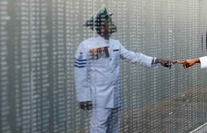 A Navy officer looks at the heroes' name board of a war memorial, during a commemoration ceremony to mark the 9th anniversary of the fallen soldiers during the final stage of war between Tamil Tigers and government army, in Colombo, Sri Lanka May 19, 2018. REUTERS/Dinuka Liyanawatte - RC19FD0E3000