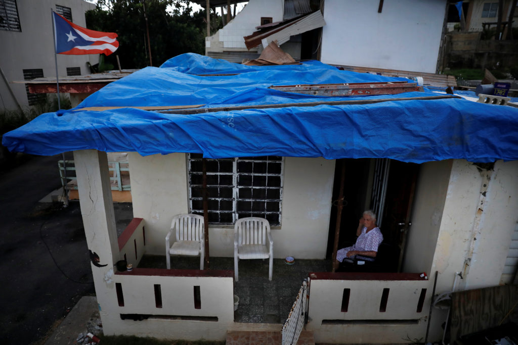 Lucila Cabrera, 86, sits at the porch of her house covered by plastic tarps over a damaged roof by Hurricane Maria, a year...