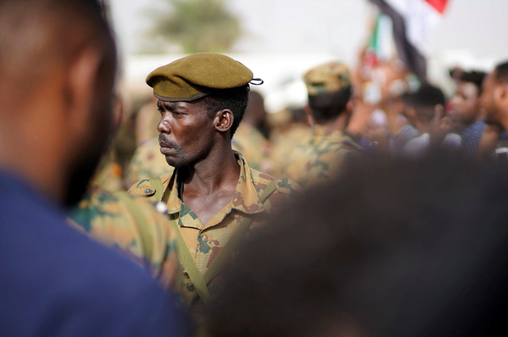 A Sudanese soldier stands guard as demonstrators attend a protest rally demanding Sudanese President Omar Al-Bashir to ste...