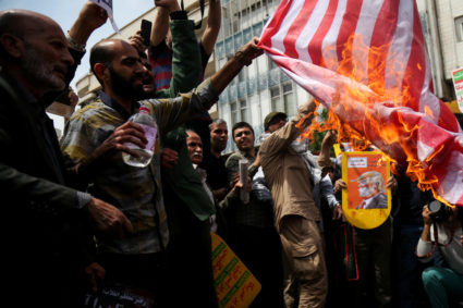 FILE PHOTO: Iranians burn a U.S. flag during a protest against President Donald Trump's decision to walk out of a 2015 nuclear deal, in Tehran, Iran, on May 11, 2018. Photo by Tasnim News Agency/via Reuters