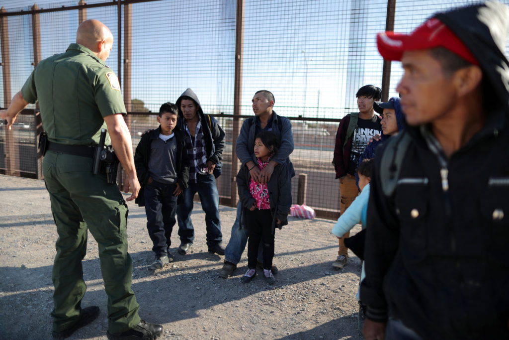 A group of Central American migrants is questioned about their children's health after surrendering to U.S. Border Patrol ...