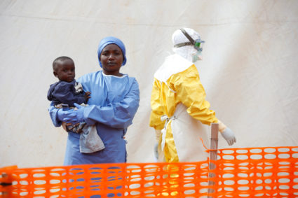 Mwamini Kahindo, an Ebola survivor working as a caregiver to babies who are confirmed Ebola cases, holds an infant outside the red zone at the Ebola treatment centre in Butembo, Democratic Republic of Congo, on March 25, 2019. Photo by Baz Ratner/Reuters