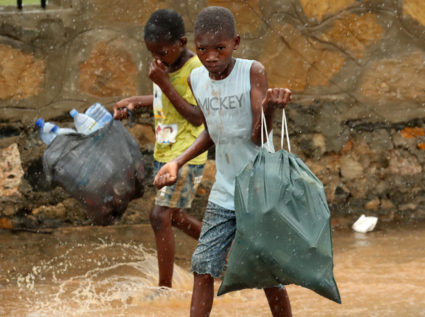 Children walk through flooded streets as rain falls in the aftermath of Cyclone Kenneth in Pemba, Mozambique, on April 30, 2019. Photo by Mike Hutchings/Reuters