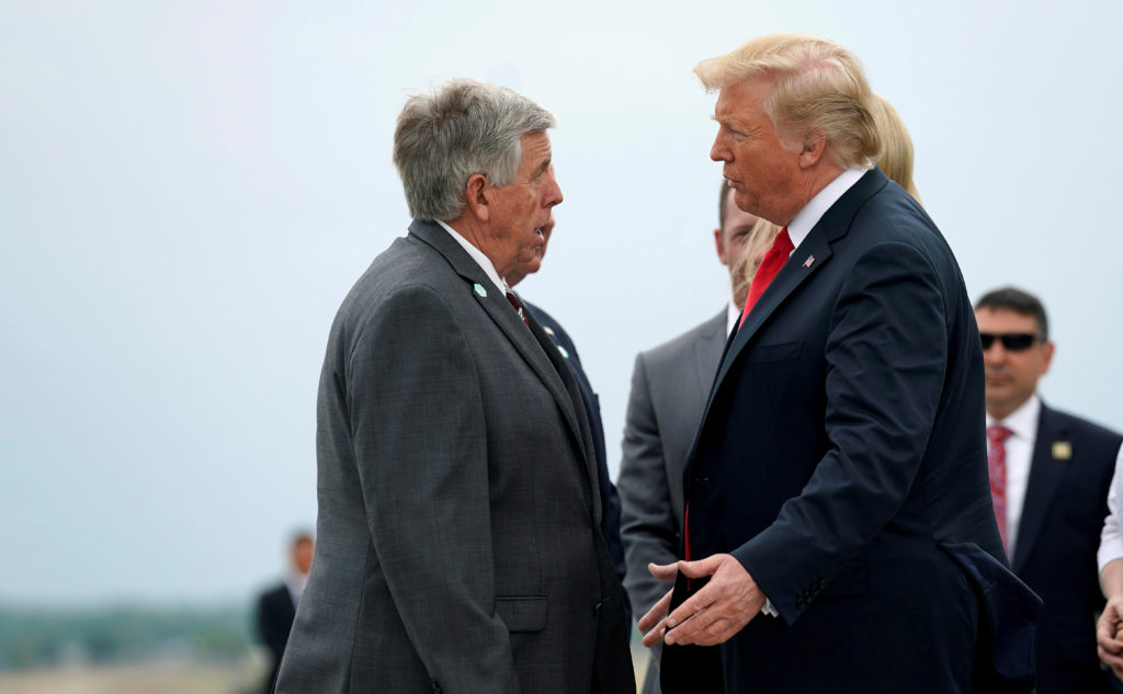 President Donald Trump speaks with the Missouri Gov. Mike Parson as he arrives in St. Louis, Missouri, U.S., July 26, 2018...