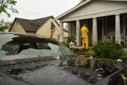 A member of the Jefferson City Fire Department checks houses for people on Woodland Avenue following a tornado touchdown overnight in Jefferson City, Missouri. Photo by Antranik Tavitian/Reuters