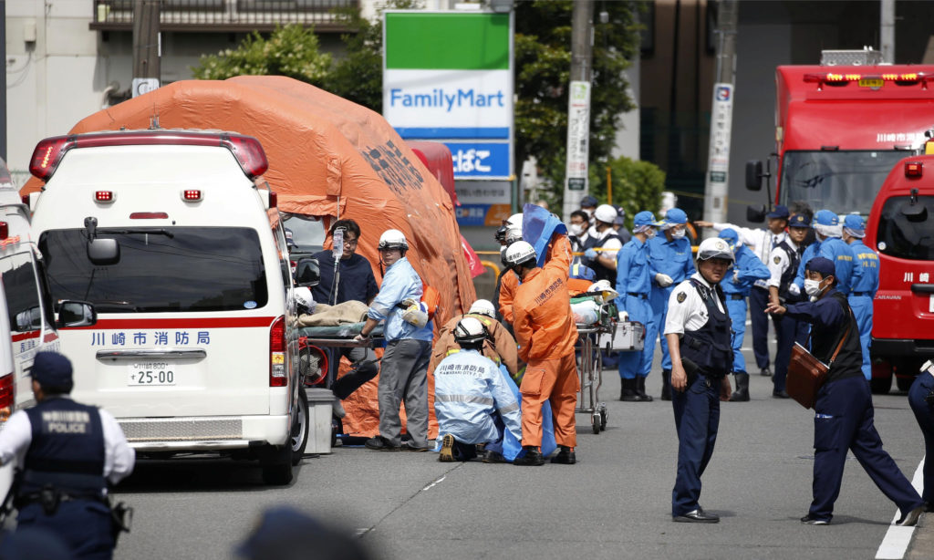 Rescue workers and police officers operate at the site where sixteen people were injured in a suspected stabbing by a man,...